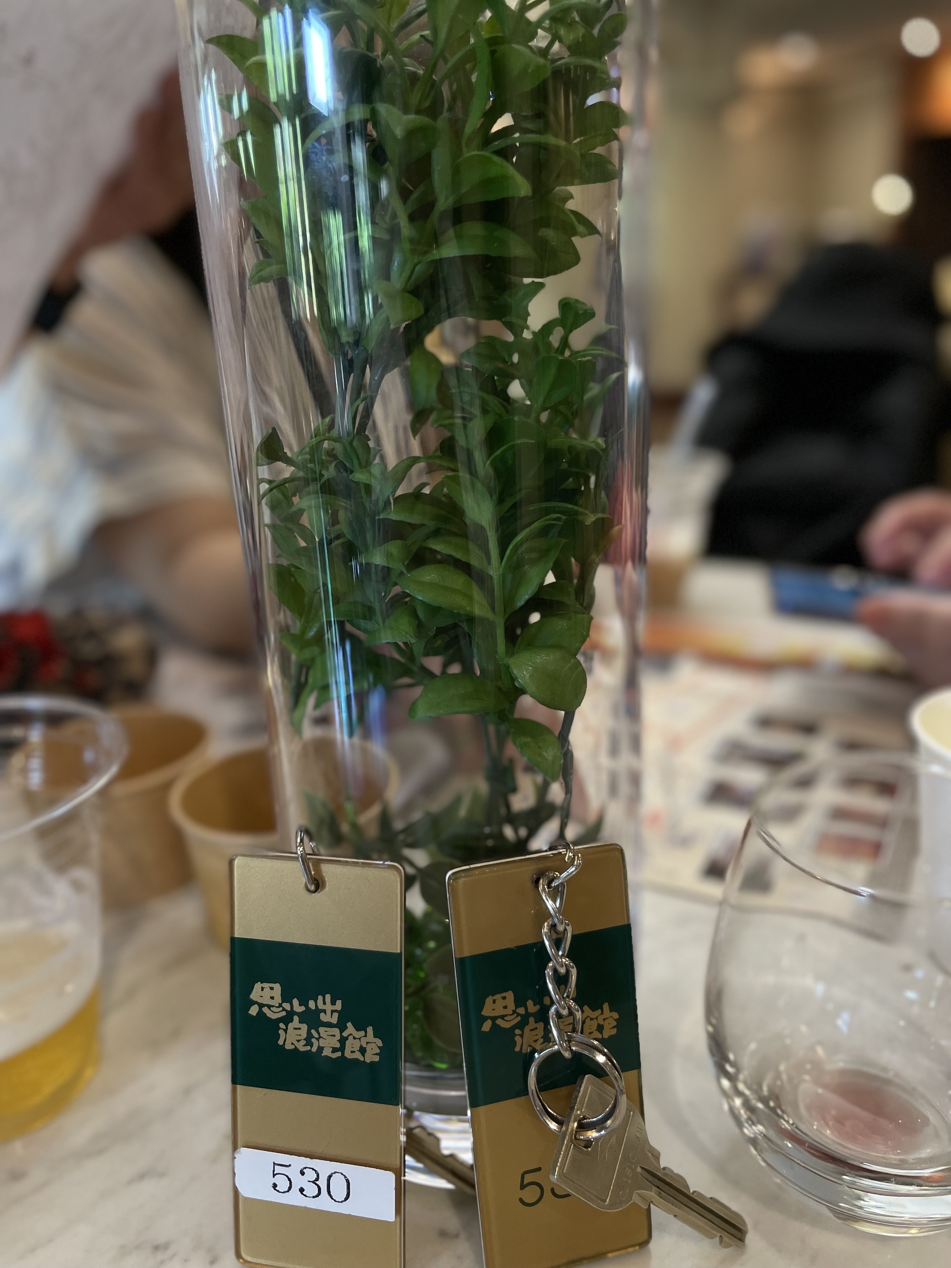 Room key tags reading Omoide Romankan resting on a table in the hotel lounge